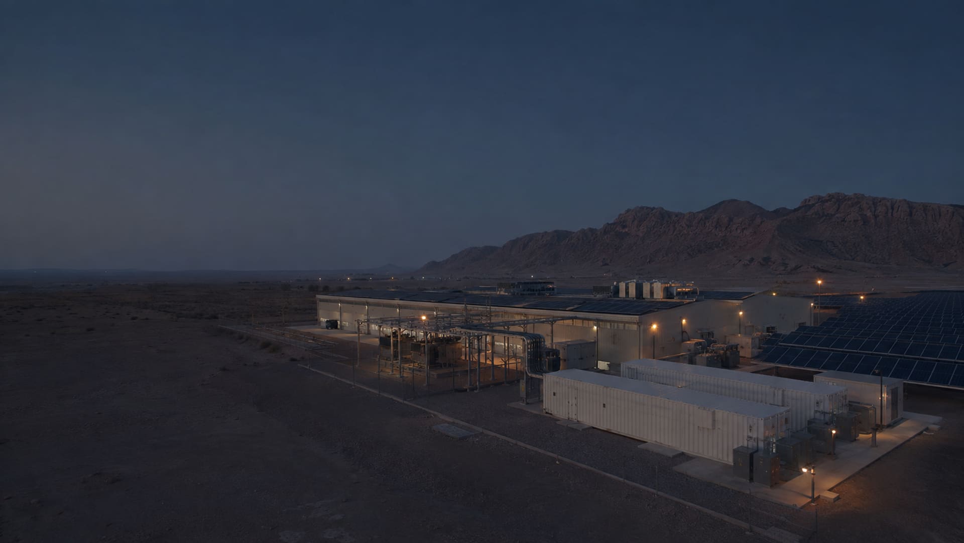 The facility at nightfall under a wide dark sky